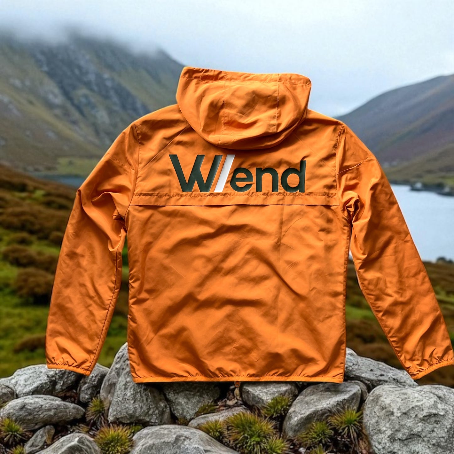 W/end Windbreaker Hot Ember Jacket with a logo on a mountainous landscape
